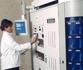 A clinician is shown interacting with the control panel of the prescription filling robot.
