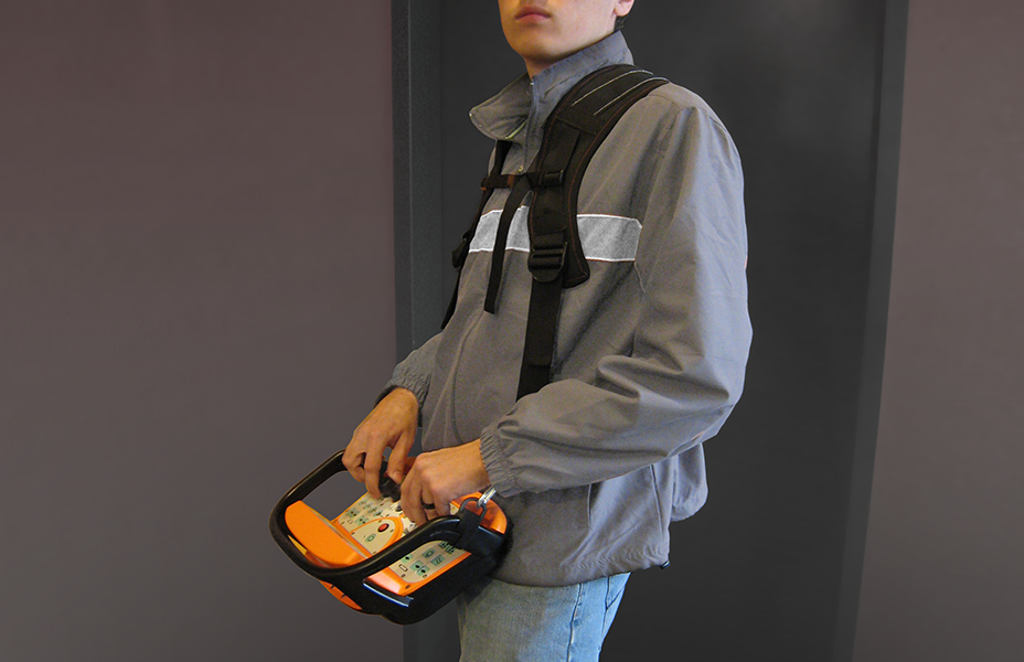 A person is shown using the Continuous Mining Remote while it is held by a harness.