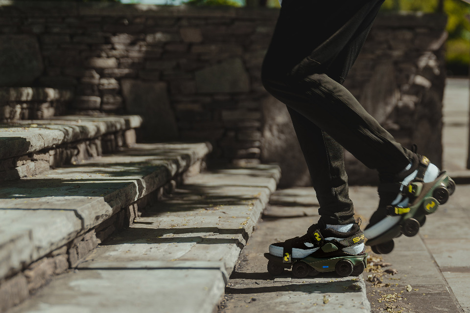 A close-up is shown of a person wearing the Moonwalkers while climbing stairs.