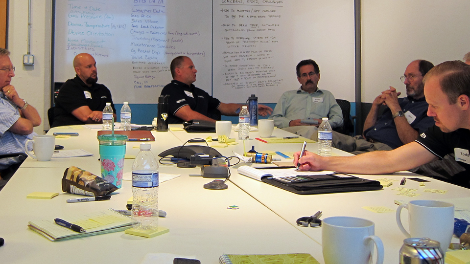 People gather around a conference table during the innovation session.
