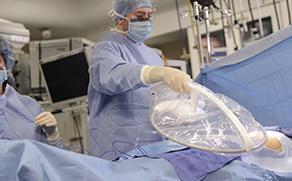 A surgeon is shown holding the RFID Surgical Wand over a patient on an operating table.