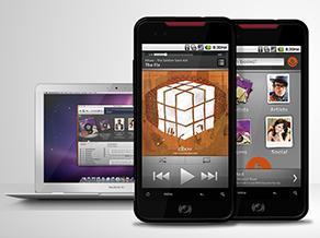 The Beyond Oblivion music app app is shown on a smart phone while a computer with the desk top application can be seen in the background.