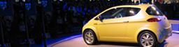 A yellow car sits on a stage.