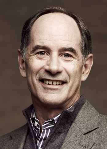 A headshot of Roger Martin on a brown background.